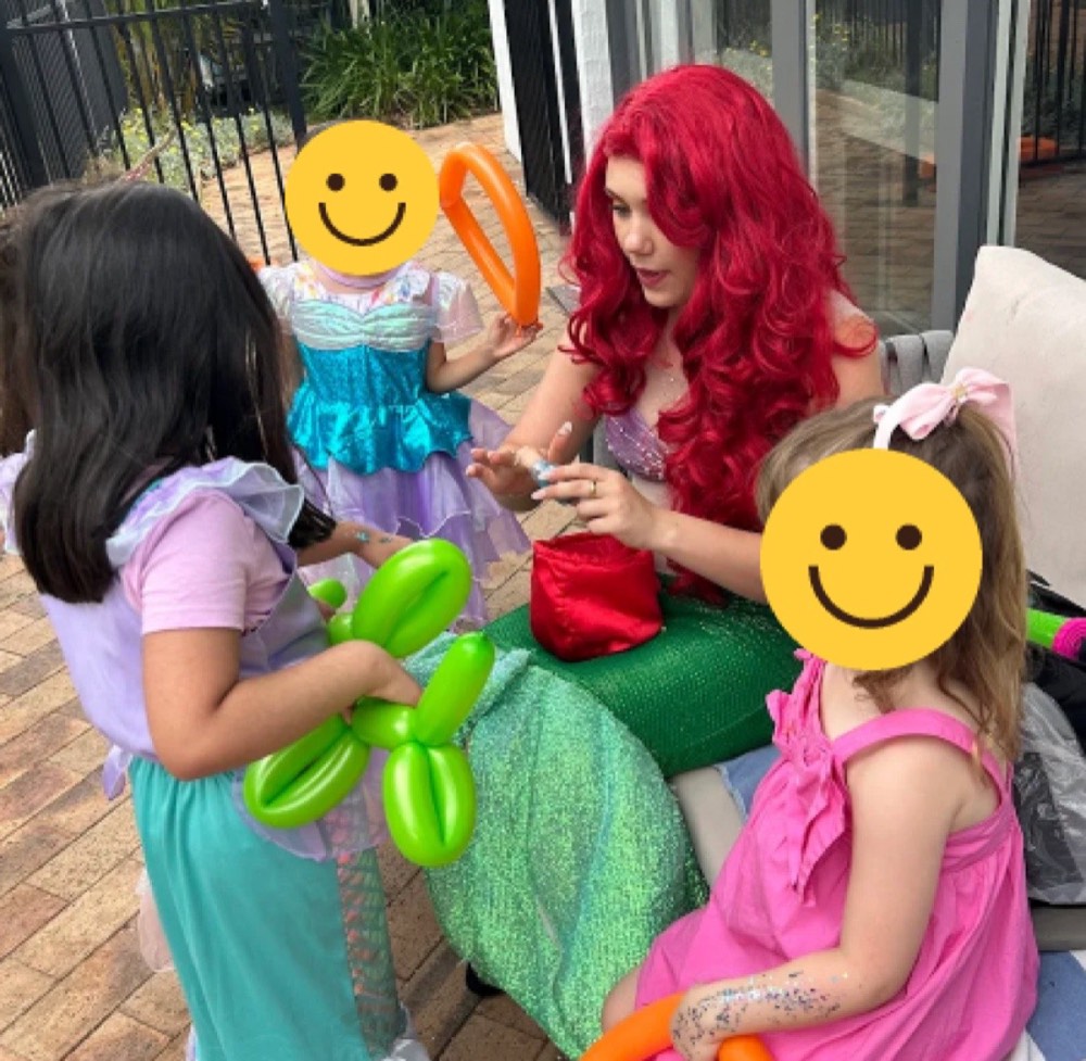 An entertainer making balloon animals with children
