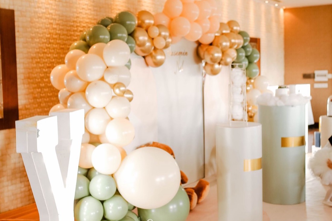 A premium balloon installation in cream, sage and gold at an elegant party venue